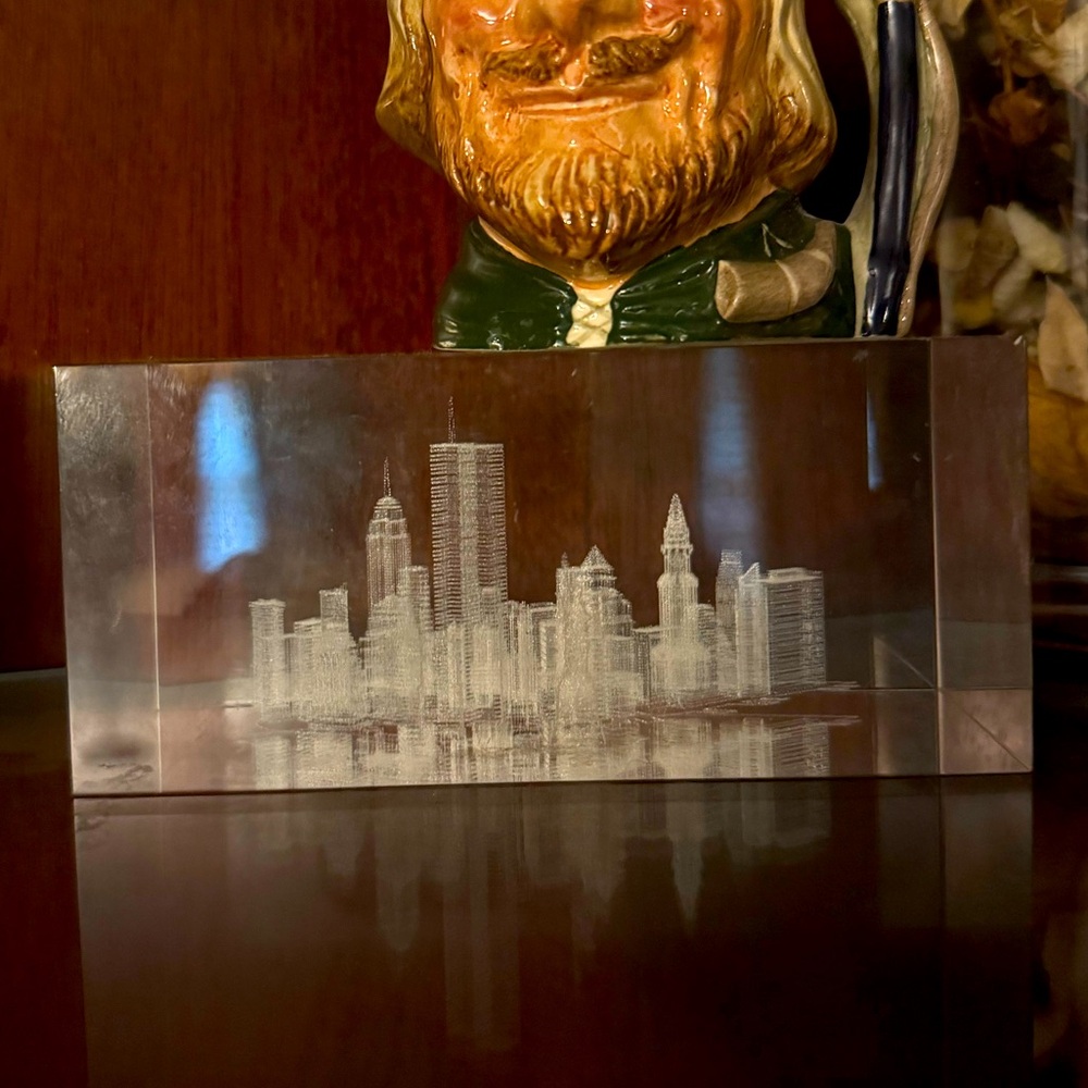 Etched block of glass of the skyline of NYC prior to 9/11. Includes twin towers.